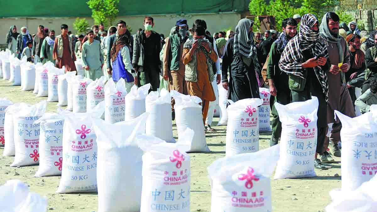 Los residentes hacen fila para recibir arroz donado por el Gobierno chino en Kabul
