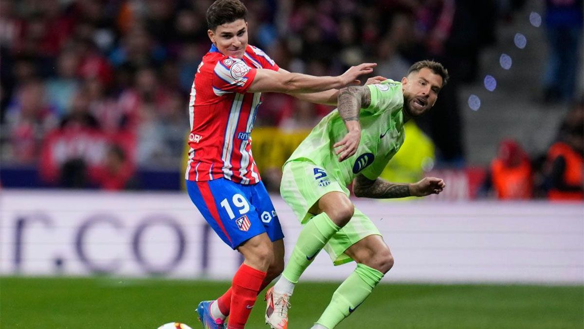 julián Álvarez le gana la posición a un jugador del Barcelona.