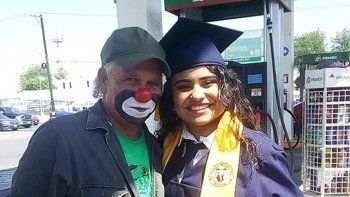Se recibió y le llevó el título a su papá, que es payaso en una estación de servicio