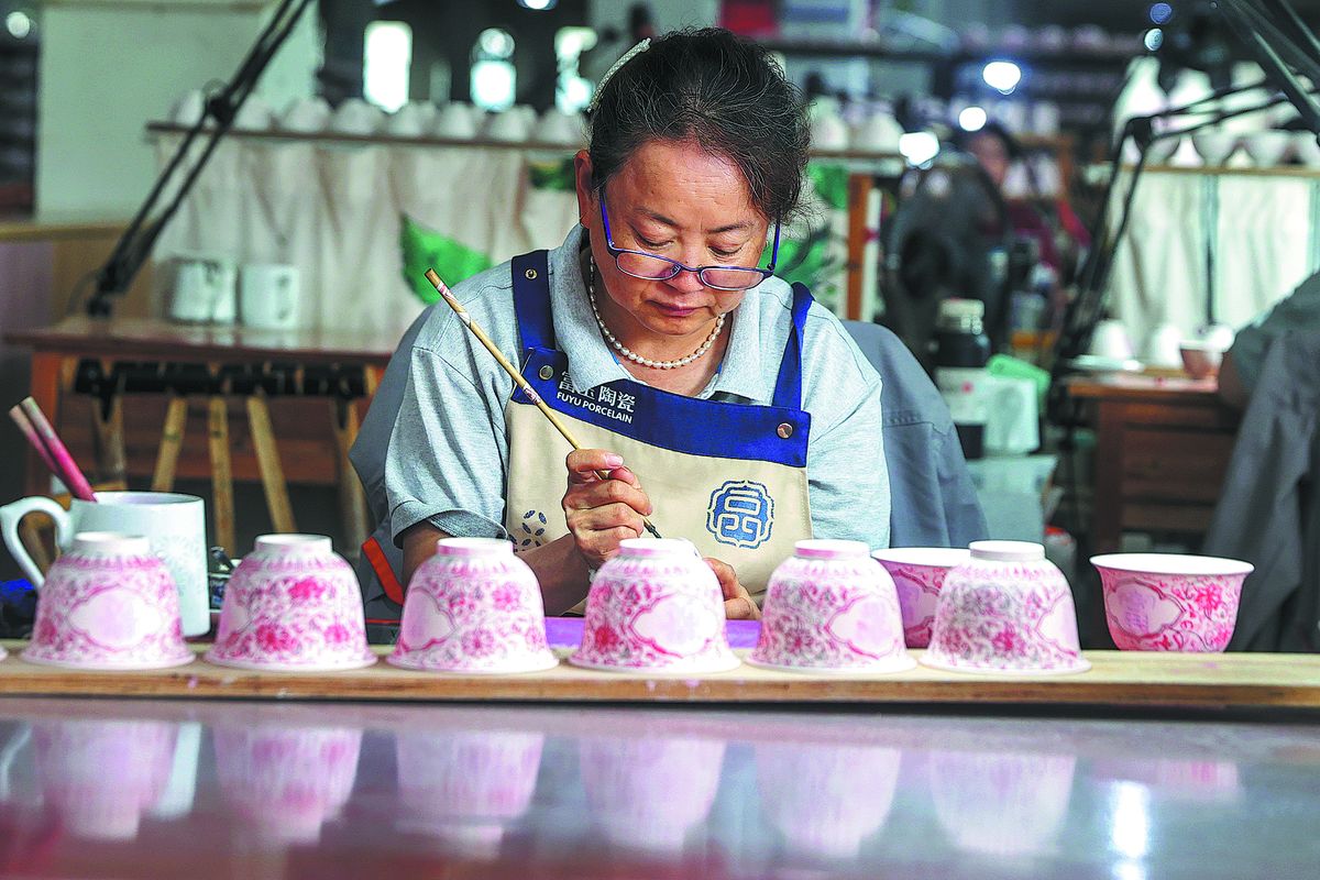 Una artesana pinta motivos florales sobre porcelana en Jingdezhen, provincia de Jiangxi, nuevo sitio de Patrimonio Mundial. LIU LIXIN / Servicio de Noticias de China.