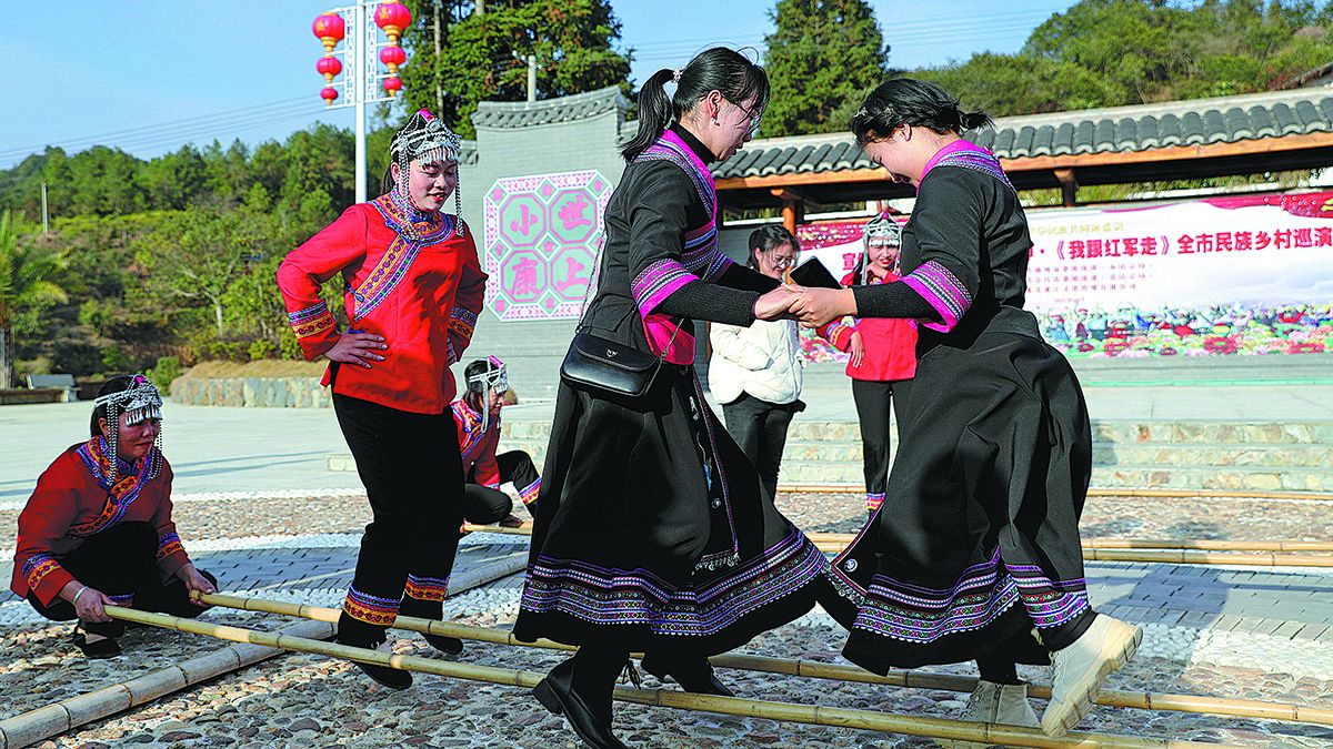 Los aldeanos del grupo étnico she bailan con los visitantes en el pubelo de Dongtou