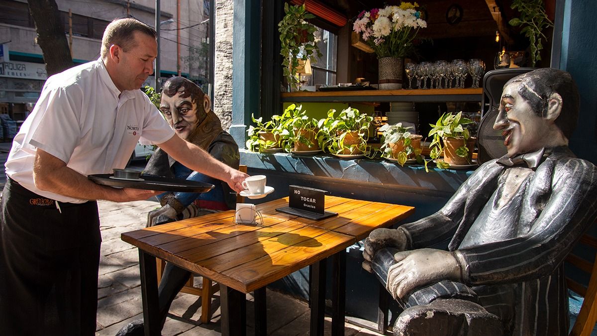 Uno de los mozos sirve café para el Zorzal Criollo bajo la atenta mirada de San Martín.