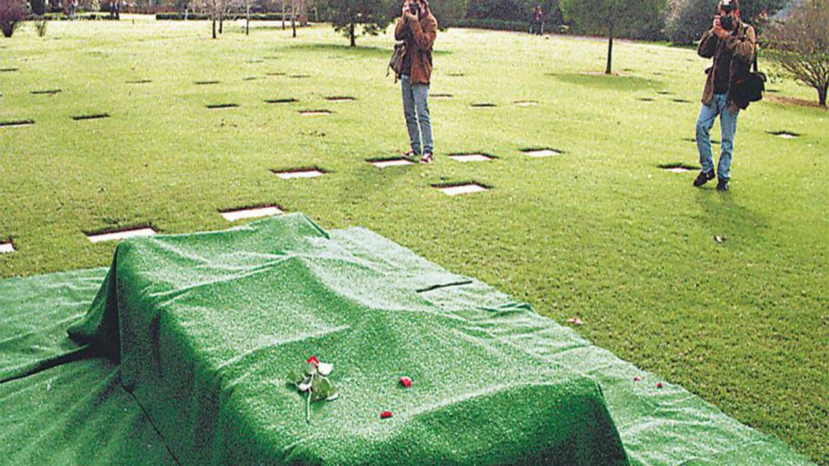 La tumba del empresario Alfredo Yabrán es fotografiada por dos reporteros gráficos.