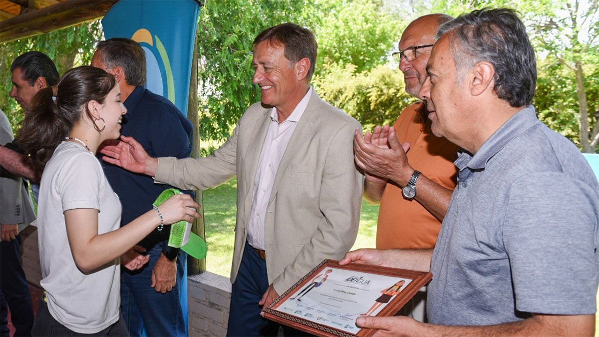 Rodolfo Suarez entrega una distinción a una estudiante que participó del concurso Ideagua. Lo acompañan Marcelino Iglesias y Alfredo Cornejo.