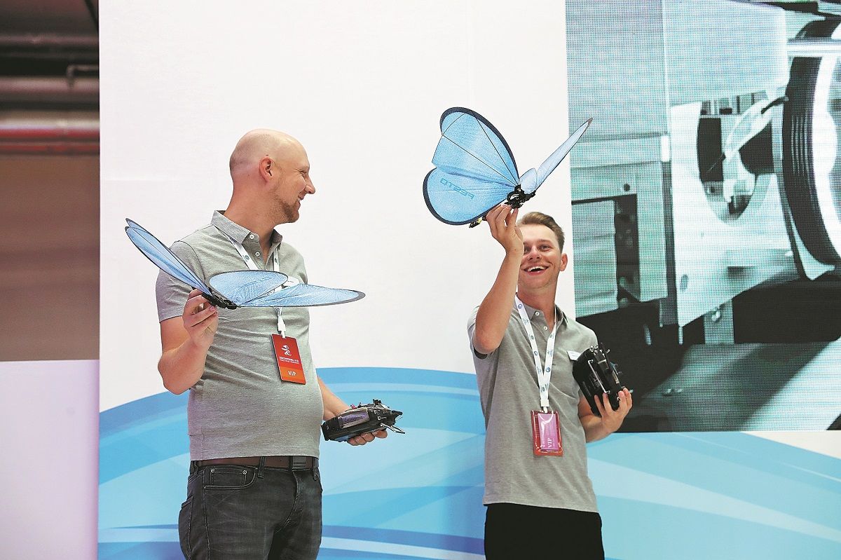 Dos empleados de la empresa alemana Festo muestran sus robots mariposa biónicos en la Conferencia Mundial de Robots 2023 en Beijing. WANG JING / CHINA DAILY