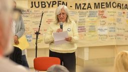 Una de las mjueres bordadoras -Ana María Villafañe- tomó la palabra. Detrás, una de las banderas bordadas con nombres de los desaparecidos de Mendoza.