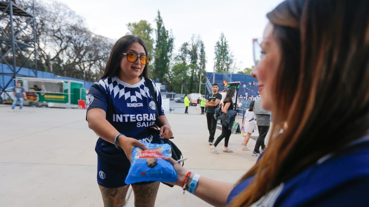 Momento preciso en que una hincha de la Lepra dona un alimento. Momento preciso en que una hincha de la Lepra dona un alimento.