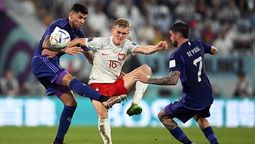 Cuti Romeroy Rodrigo De Paul luchan con un jugador de Polonia.