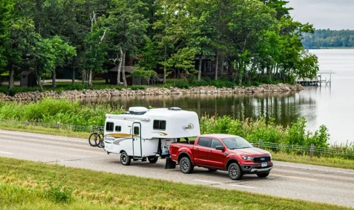 La vista exterior lateral del Scamp 19 revela las características clave que lo convierten en una opción duradera y confiable para los amantes del campamento. Su construcción de fibra de vidrio moldeada, visible en su forma redondeada y aerodinámica, garantiza resistencia y minimiza el riesgo de fugas, asegurando una larga vida útil. La puerta lateral con ventana integrada y el toldo opcional ofrecen funcionalidad y protección contra los elementos al configurar el campamento.&nbsp;