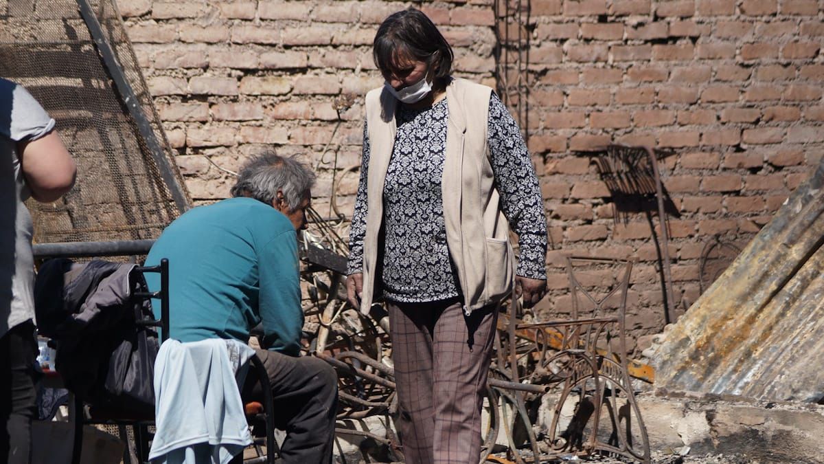 Una familia desconsolada, viendo los restos de su casa arrasada por el fuego Una familia desconsolada, viendo los restos de su casa arrasada por el fuego