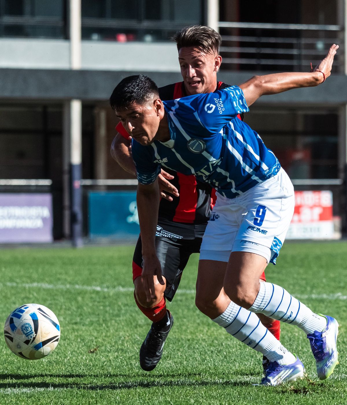 Martín Pino, de Godoy Cruz, lucha contra un defensor del Dragón en el partido disputado en Núñez por la 2ª fecha de la Primera Nacional.