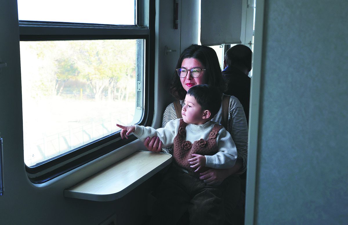 Gulbar Herem y su hijo toman el tren hacia Qira, un condado al sur de la Región Autónoma Uygur de Xinjiang. FENG YONGBIN / CHINA DAILY Gulbar Herem y su hijo toman el tren hacia Qira, un condado al sur de la Región Autónoma Uygur de Xinjiang. FENG YONGBIN / CHINA DAILY