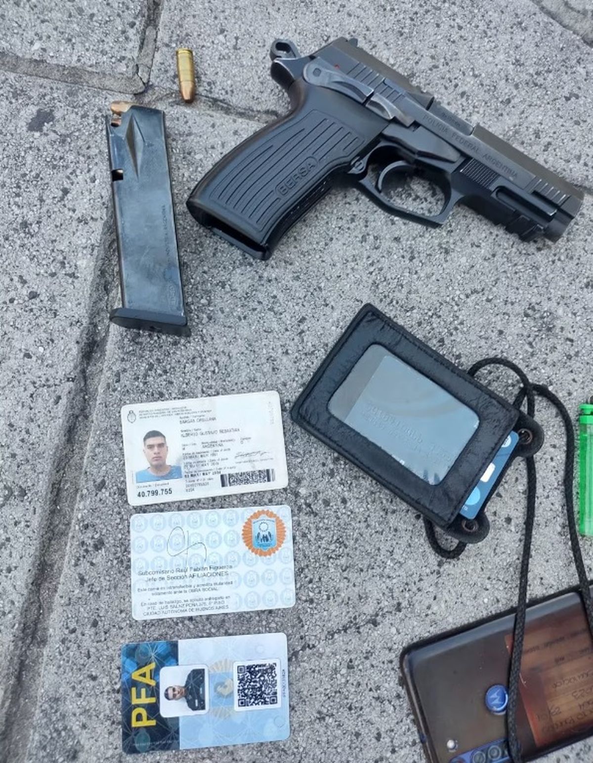 La documentación del efectivo de la Policía Federal, y el arma reglamentaría con la que efectuó los disparos