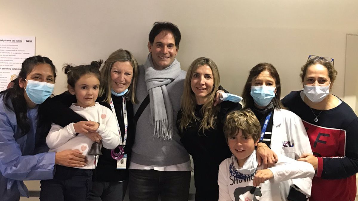 Historia de vida con final feliz. Catalina Santo Tomás posa abrazada por la oncóloga Angie Fernández Barbieri, campanita en mano, y sus padres, Gonzalo y Elena y personal del Hospital Alemán de Buenos Aires, de donde recibió el alta definitiva de su tratamiento contra el cáncer.