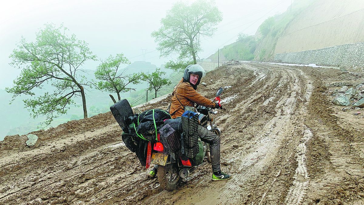 Mads Nielsen (en la imagen) y su compañero Anthony Tao recorrieron caminos de barro en las laderas de las montañas. PARA USO DE CHINA DAILY &nbsp;