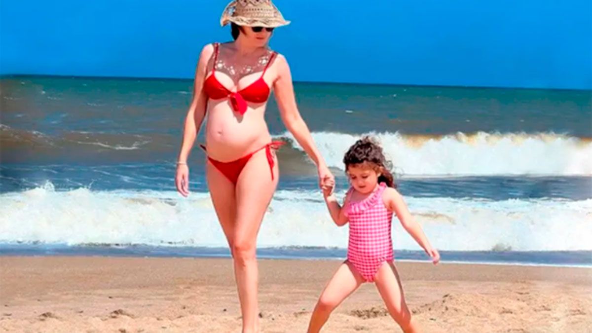 Isabel Macedo embarazada de 6 meses junto a Belita en la playa.