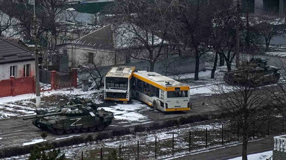 Micros ucranianos bloquean el paso de un tanque ruso en la ciudad de Mariúpol.