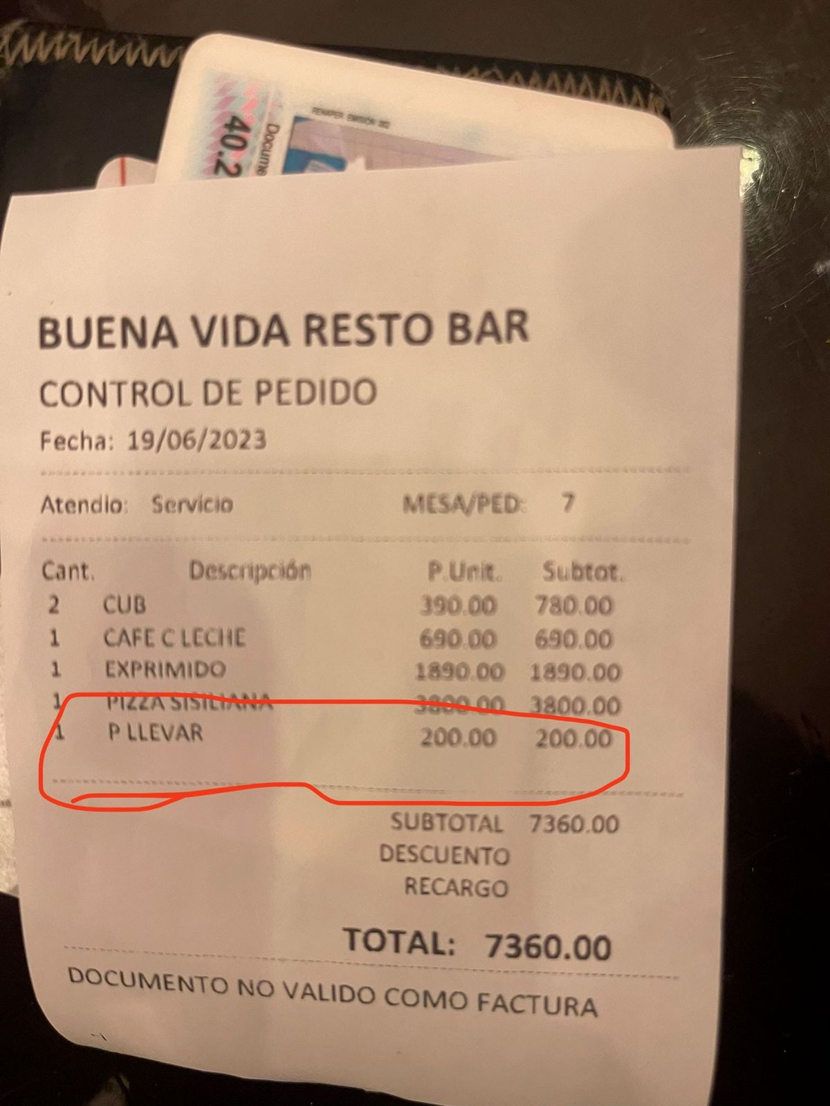 El joven fotografió el ticket con el detalle del recargo por llevarse las sobras de la pizza. 
