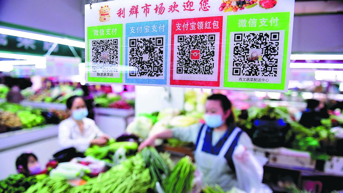 Se alienta a los clientes de un mercado de verduras en Shenyang, provincia de Liaoning, a utilizar el pago electrónico. PARA USO DE CHINA DAILY