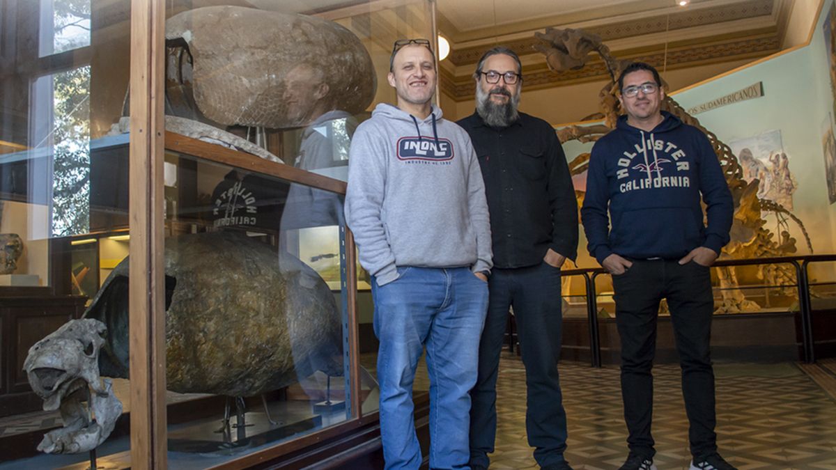 Los investigadores que realizaron el descubrimiento, junto a un fósil de gliptodonte. Los investigadores que realizaron el descubrimiento, junto a un fósil de gliptodonte.