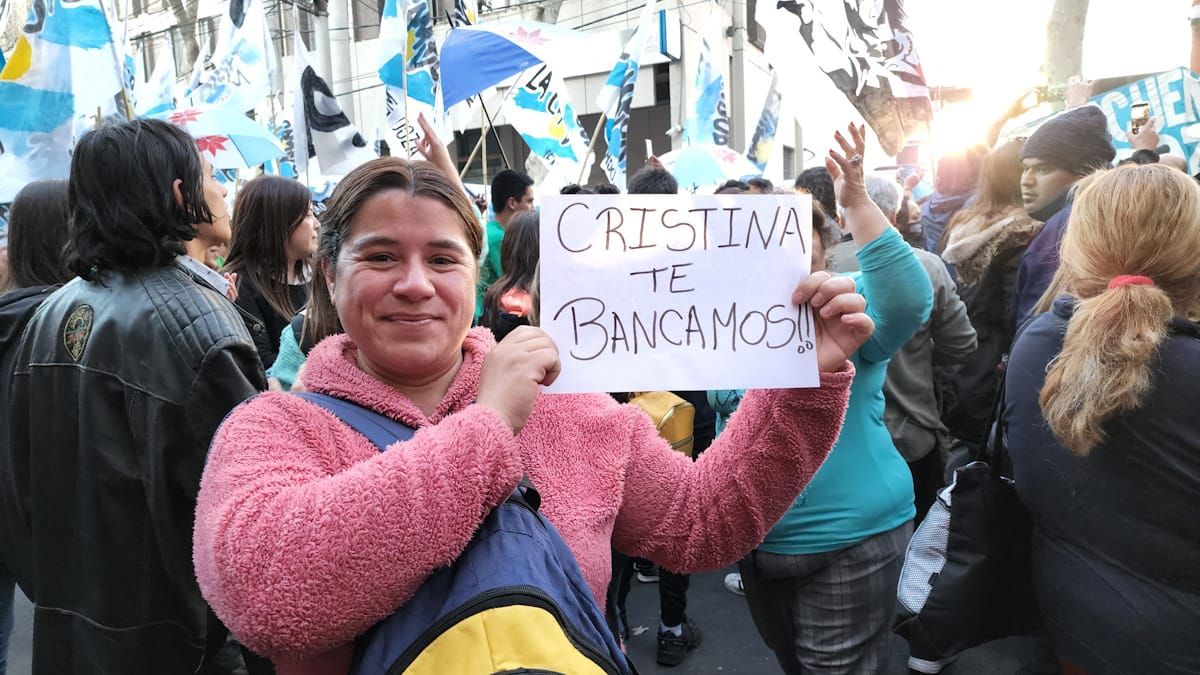 Orgullosa, la mujer muestra el cartel que ella misma escribió: