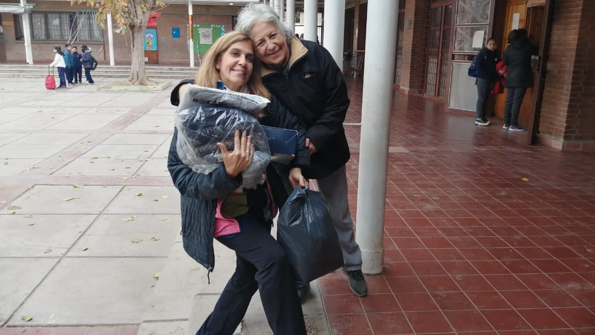 Valeria recibiendo la donación de una vecina que se movilizó al conocer lo que había pasado.