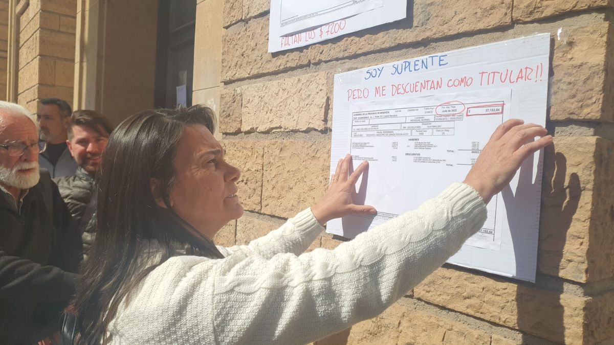 Carina Sedano la titular del SUTE, pegando bonos de sueldo con los descuentos en as paredes de la Casa de Gobierno.