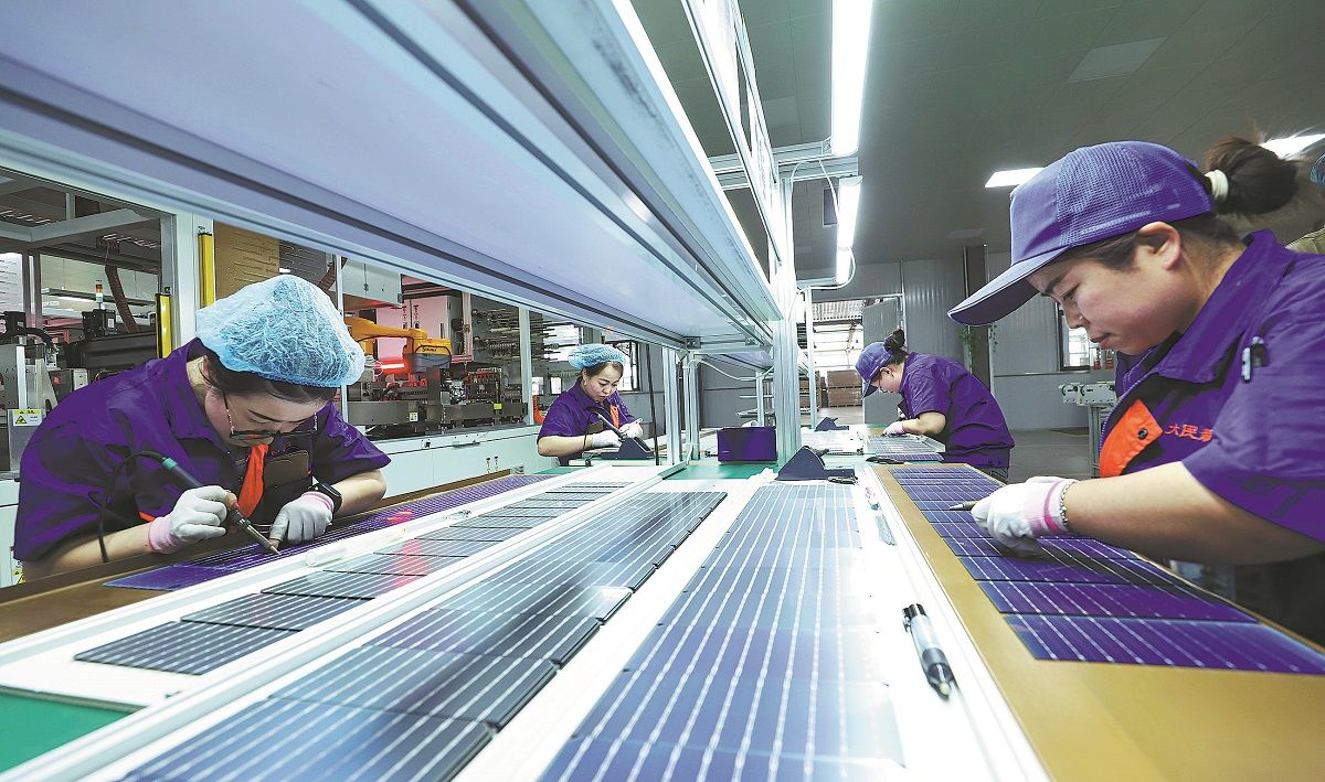 Unas empleadas revisan productos de paneles solares en una empresa de tecnología en Zhangye