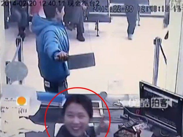 La cajera de un banco se ríe de un atracador que lleva un cuchillo de carnicero
