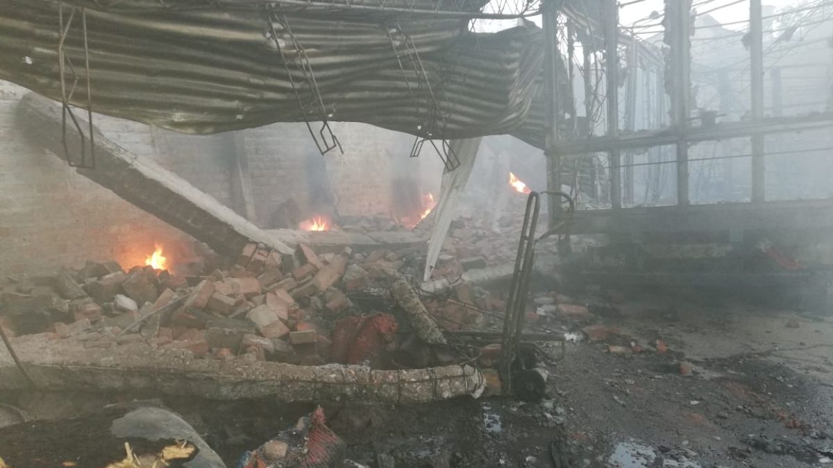 Se puede apreciar en primer plano la carrocería de un camión, y un techo y paredes caídas, además del techo, dentro del galpón siniestrado en San José, Guaymallén.