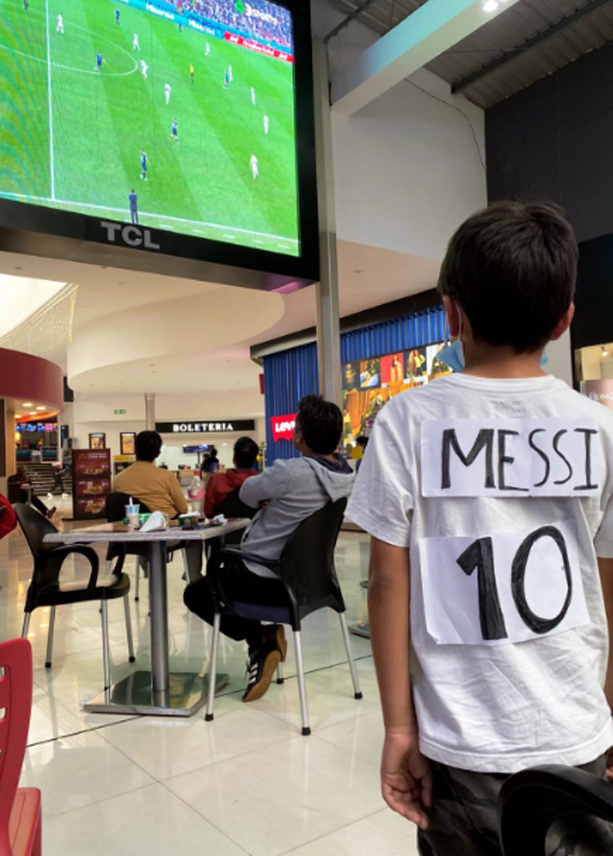 Benjamín, de 9 años, viendo a Lionel Messi con su camiseta en un shopping de Cuenca