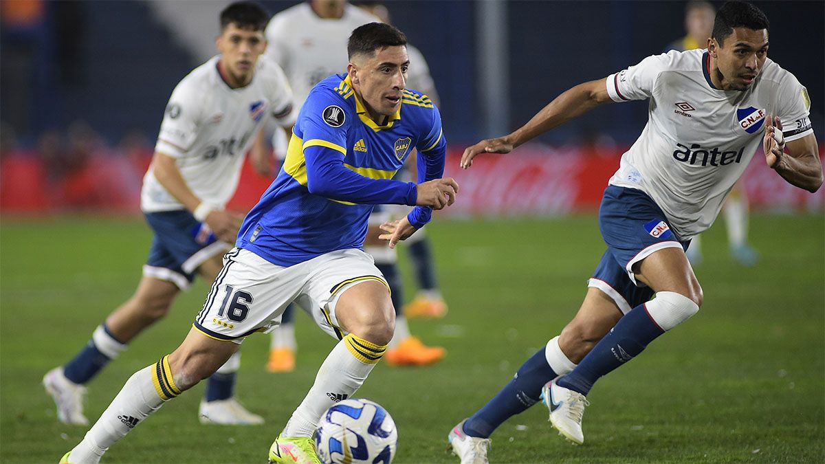 Miguel Merentiel, de Boca, lleva la pelota y es seguido de cerca por los jugadores de Nacional.