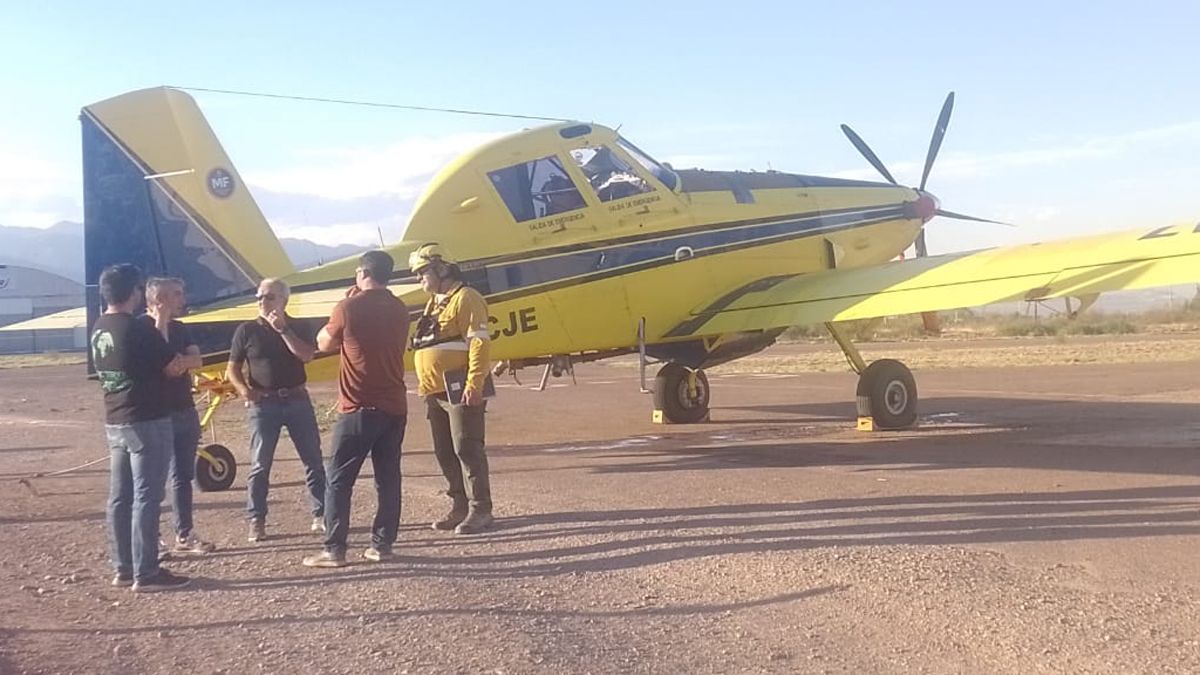 Sebastián Bragagnolo con el secretario de Ambiente, Humberto Mingorance y brigadistas. Detrás, uno de los aviones hidrantes que envió el gobierno de Buenos Aires.