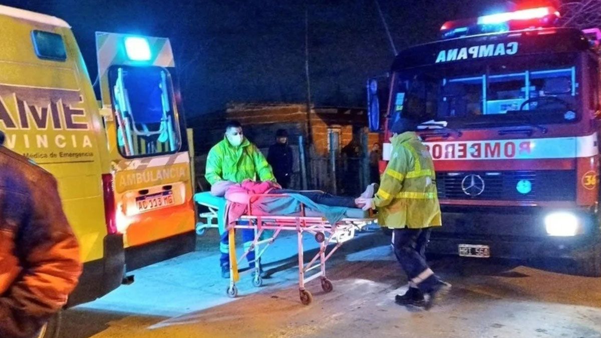 El cuerpo de la mujer es retirado por los bomberos que acudieron al incendio de una vivienda en Campana. 