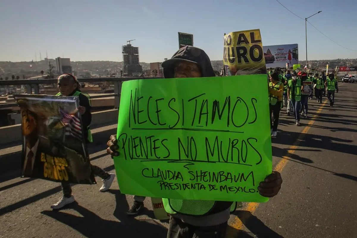 Una persona sostiene un cartel durante una manifestación de migrantes en el puerto internacional de San Ysidro, en la ciudad fronteriza de Tijuana en México. Crédito: EFE/Joebeth Terriquez. Una persona sostiene un cartel durante una manifestación de migrantes en el puerto internacional de San Ysidro, en la ciudad fronteriza de Tijuana en México. Crédito: EFE/Joebeth Terriquez.