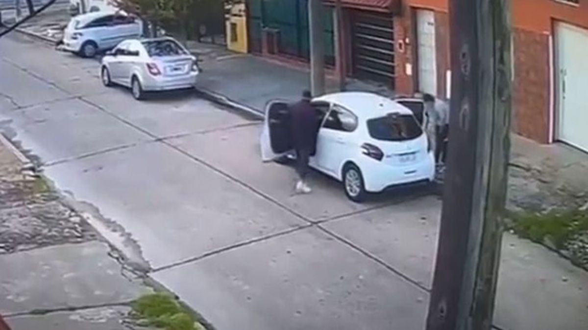 El momento en que los delincuentes sorprenden a la mujer, que tenía a su hijo en brazos, para robarle el auto, en La Matanza. Una vecina activó la alarma comunitaria,