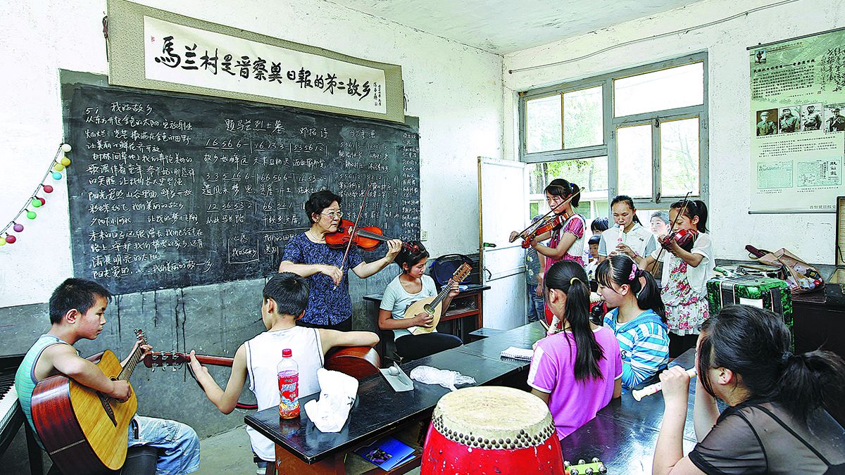Deng Xiaolan practica con los niños de la banda de música de Malan que ella creó en el condado de Fuping