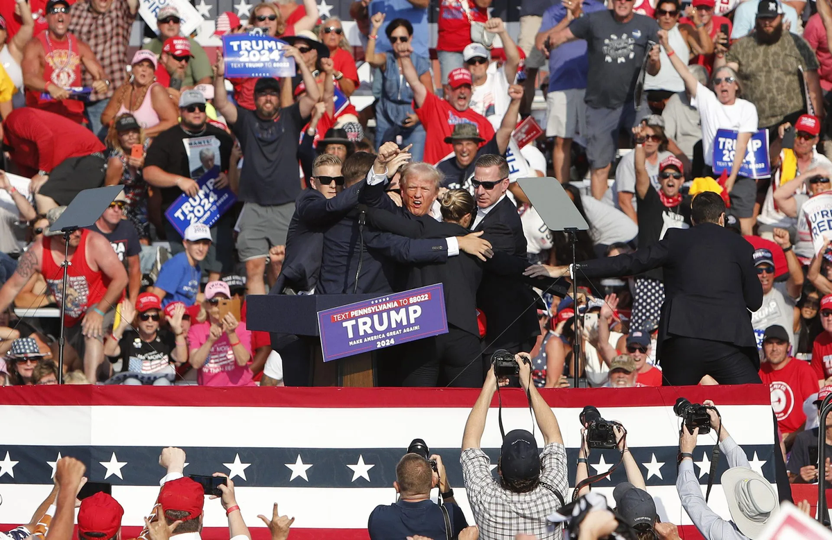 Donald Trump levanta el puño mientras el Servicio Secreto lo saca del escenario después del atentado en un mítin de campaña en Pensilvania el pasado julio. Crédito: EFE/EPA/David Maxwell.