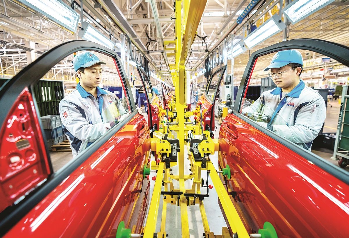 Los empleados trabajan en una línea de montaje final de vehículos de nueva energía en Yuncheng, provincia de Shanxi. YAN XIN / PARA CHINA DAILY