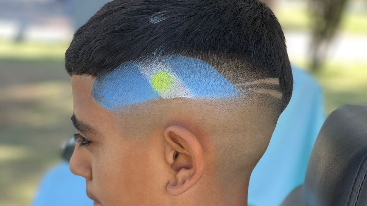 Listo el look del Dibu Martínez. Darío Rodríguez y sus colaboradores le hicieron el corte de pelo y la banderita argentina en forma gratuita a los chicos en la plaza de Tunuyán.