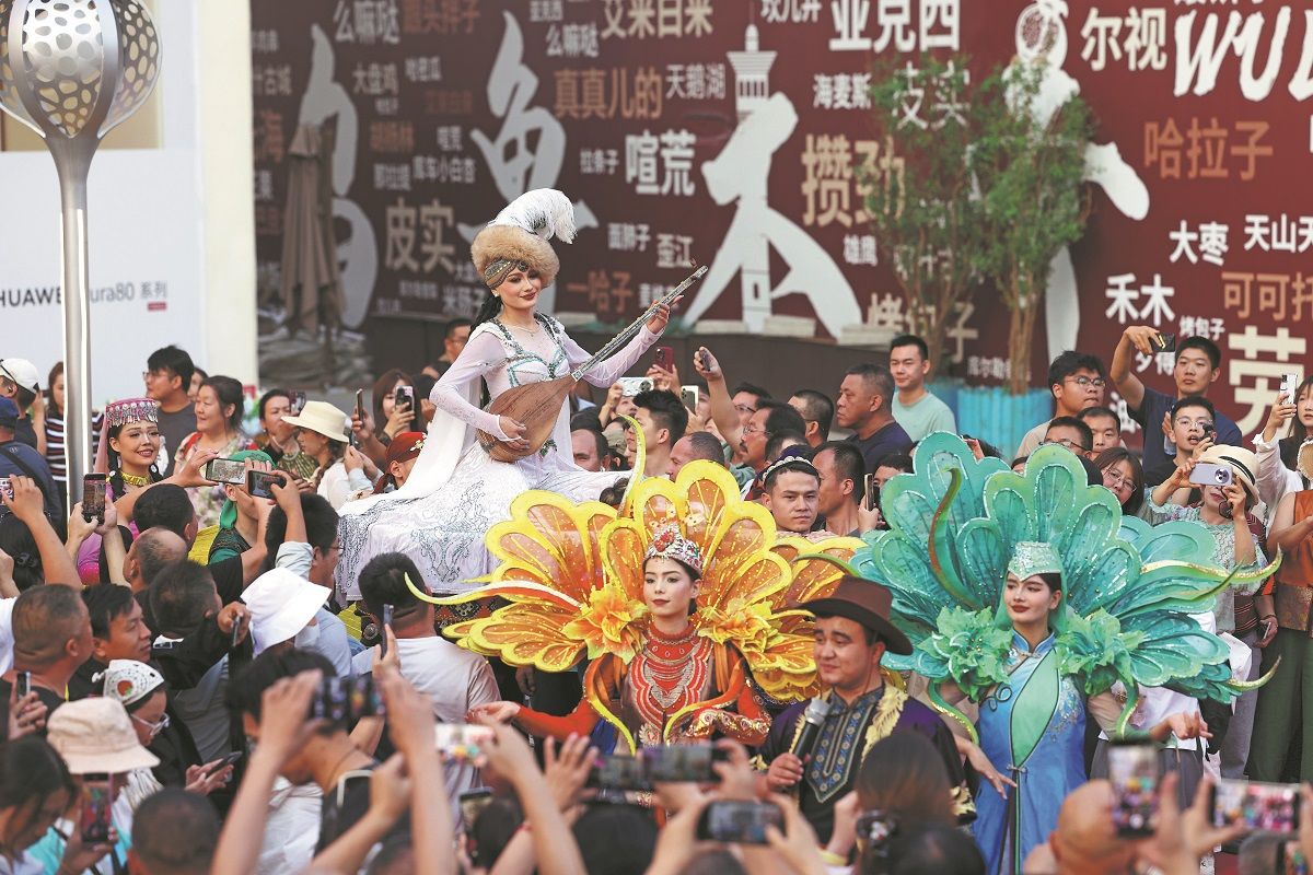 Artistas vestidos con trajes étnicos tradicionales actúan en el Gran Bazar de Urumqi