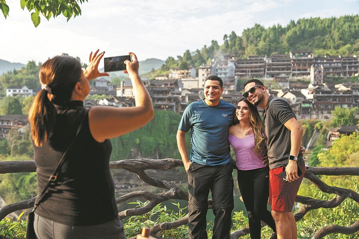 Turistas extranjeros posan para una foto en Yongshun, provincia de Hunan, el 7 de noviembre. CHEN SIHAN / XINHUA. Turistas extranjeros posan para una foto en Yongshun, provincia de Hunan, el 7 de noviembre. CHEN SIHAN / XINHUA.