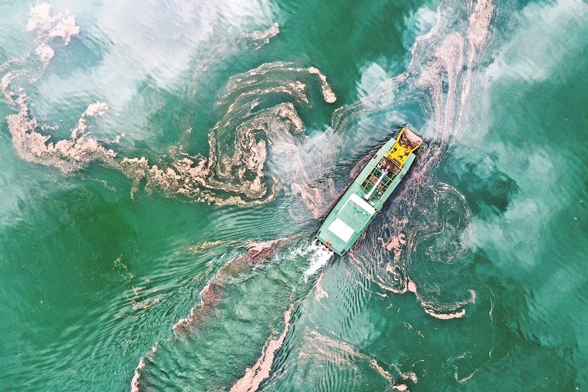 Un barco de limpieza recoge la basura sobre el río Wujiang en Bijie. OU DONGQU / XINHUA