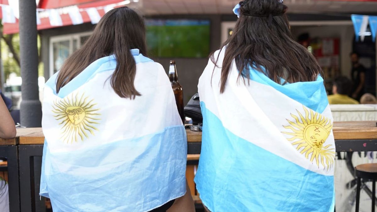 Enbanderadas. Dos amigas esperan el inicio del partido, con una previa de cerveza.