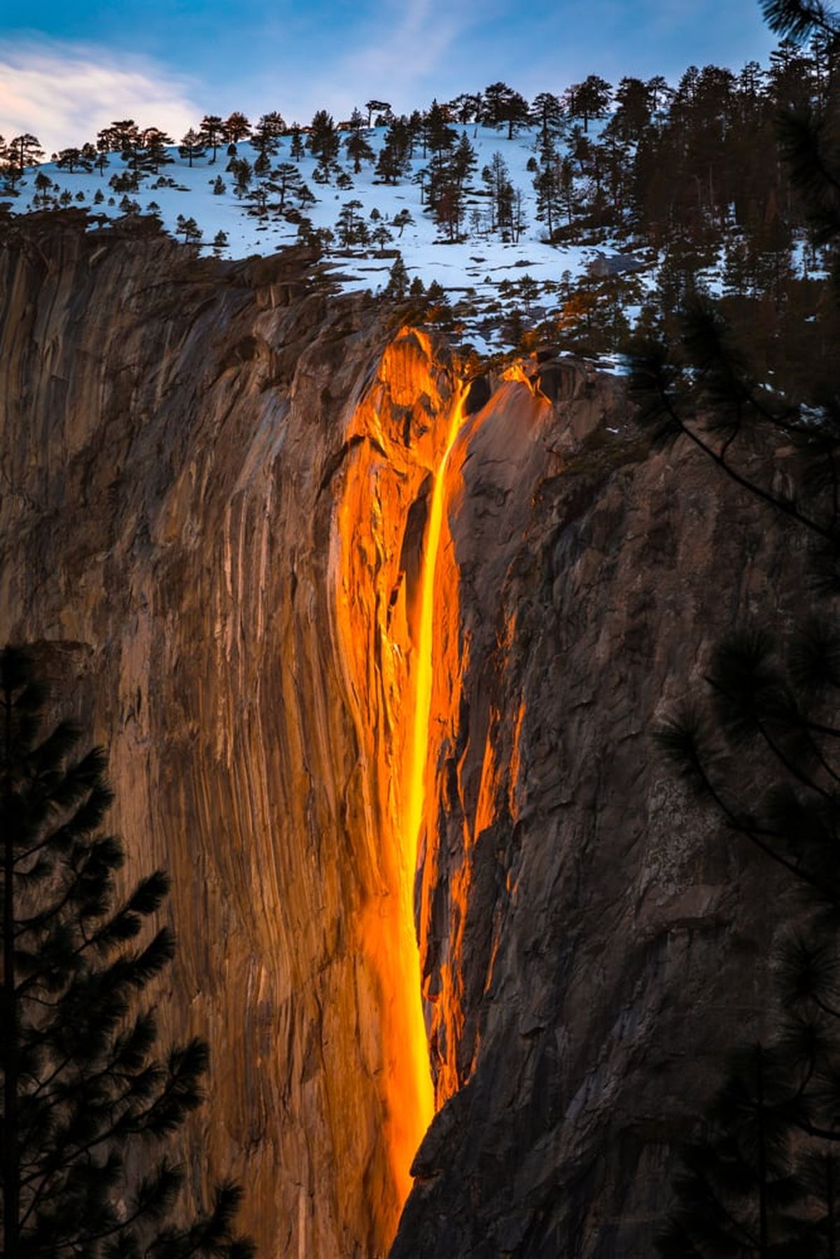 El agua de color naranja y rojo brillante brota del acantilado con la intensidad visual de un incendio forestal desenfrenado. El agua de color naranja y rojo brillante brota del acantilado con la intensidad visual de un incendio forestal desenfrenado.