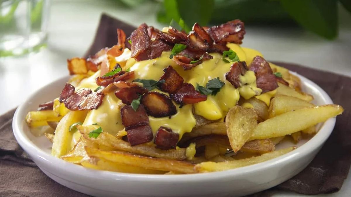 Las papas fritas con panceta y queso cheddar es un menú que con el pasar de los años se transformó en un clásico Las papas fritas con panceta y queso cheddar es un menú que con el pasar de los años se transformó en un clásico