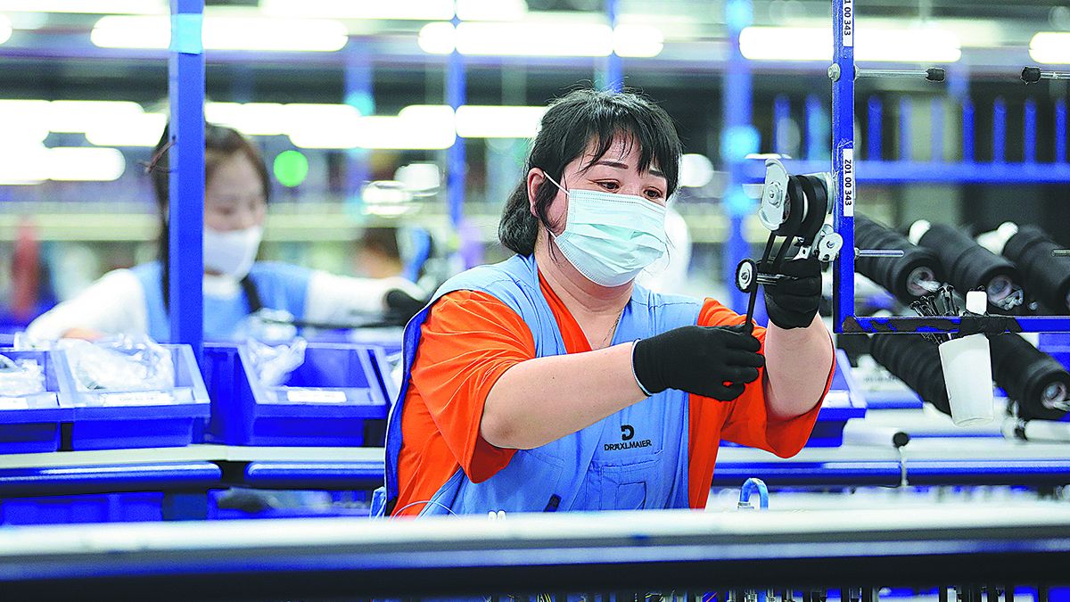 Unas empleadas trabajan en la línea de producción de componentes para automóviles de una empresa alemana en Anshan