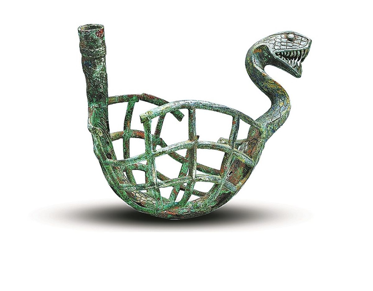 Un artefacto de bronce en forma de telaraña con diseño de serpiente del antiguo reino Dian, del Período de los Reinos Combatientes (475-221 a.C.). PARA USO DE CHINA DAILY Un artefacto de bronce en forma de telaraña con diseño de serpiente del antiguo reino Dian, del Período de los Reinos Combatientes (475-221 a.C.). PARA USO DE CHINA DAILY