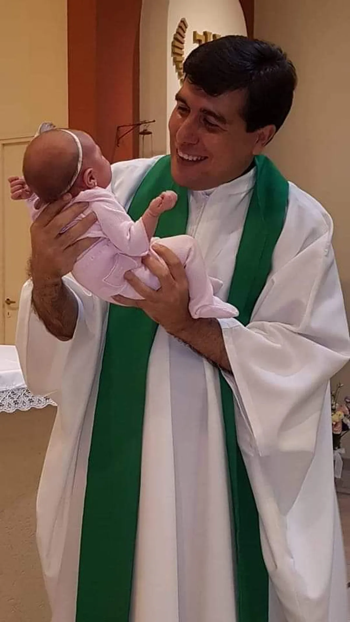 El sacerdote con una pequeña feligresa.