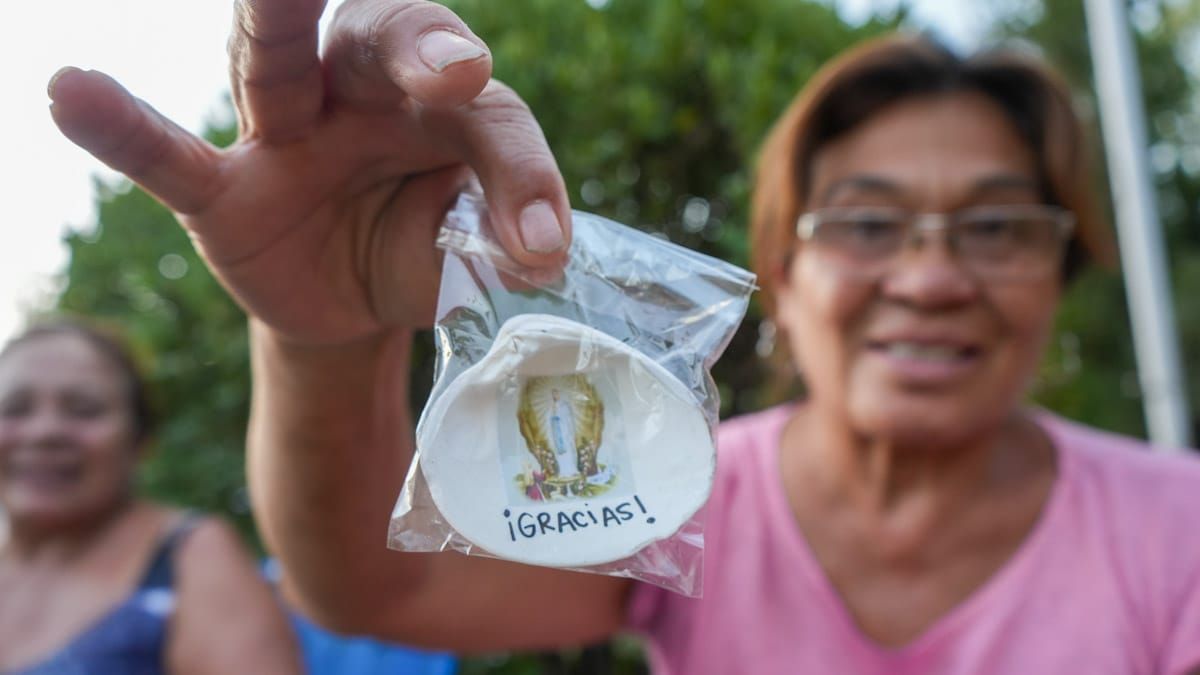 ¡Gracias! Con felicidad y emoción la mujer muestra una estampita de la Virgen. ¡Gracias! Con felicidad y emoción la mujer muestra una estampita de la Virgen.